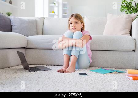 In voller Länge Foto von frustriert Mädchen sitzen Boden Teppich verpassen Freunde studieren Remote Corona Virus Quarantäne im Haus drinnen Stockfoto