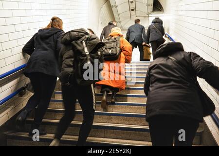 London, Vereinigtes Königreich - 01. Februar 2019: Anonyme Passagiere, die von der U-Bahn aus Treppen steigen, Blick von hinten, etwas Bewegung verwischen Stockfoto