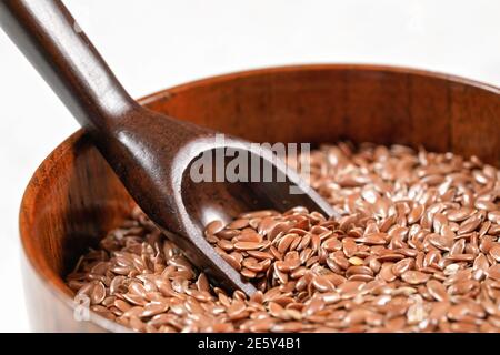 Leinsamen in kleiner Holzschale mit Holzlöffel, Nahaufnahme Detail Stockfoto