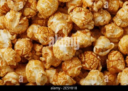 Popcorn in Karamell Glasur Nahaufnahme als Hintergrund. Köstliches Lob für das Ansehen von Filmen, Serien, Cartoon. Nahaufnahme Stockfoto