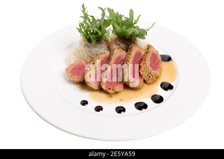 Thunfisch Tataki wird mit Sesam und Rucola paniert. Isoliert auf weißem Hintergrund. Nahaufnahme. Stockfoto