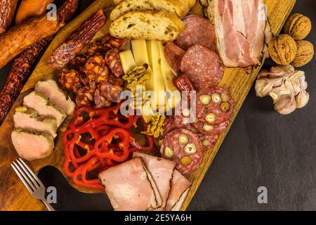 Verschiedene Arten von Salami, Speck und Würstchen auf einem Holztisch. Fat Junk Food. Geräuchertes Fleisch. Adipositas-Konzept. Übergewicht. Stockfoto