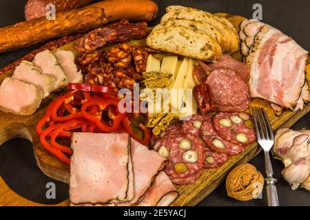 Verschiedene Arten von Salami, Speck und Würstchen auf einem Holztisch. Fat Junk Food. Geräuchertes Fleisch. Adipositas-Konzept. Übergewicht. Stockfoto