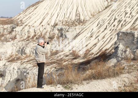 Der Fotograf macht ein Landschaftsaufnahmen. Er befindet sich in einer alten verlassenen Karriere. Stockfoto