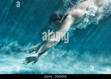 Seitenansicht des mittleren gealterten Mann Schwimmen unter Wasser Stockfoto