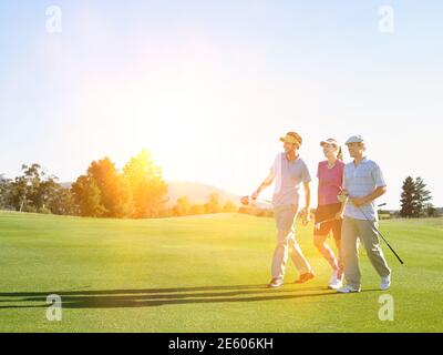 Portrait von jungen Golfern, die auf dem Golfplatz spazieren Stockfoto