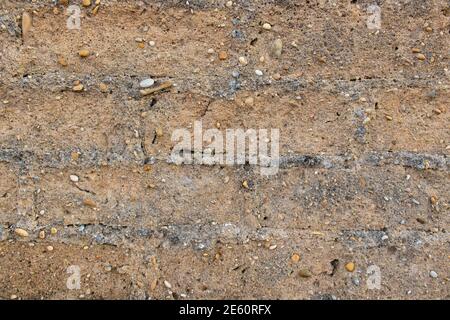 Ton Wand Hintergrund. Detail der alten Mauer aus Lehm mit grob gebauten Ziegeln und gemischten Kieselsteinen. Textur von rauen rustikalen Wand mit Kopierer Platz Stockfoto