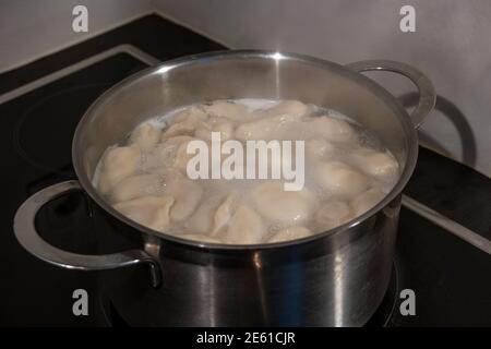 Kochen Knödel mit Fleisch durch Kochen in Wasser in einer Pfanne, Details, Nahaufnahme. Stockfoto