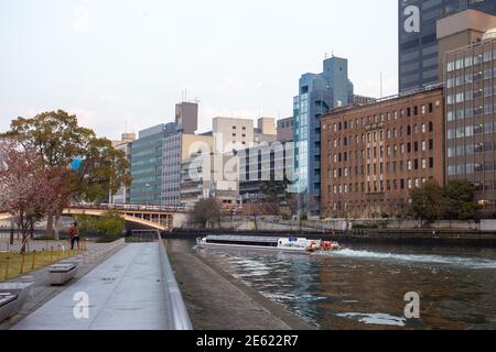 Vergnügungsboot (touristisch) auf dem Fluss O in Osaka. Spiegelung von Gebäuden im Wasser. Platz neben Rosengarten Nakanoshima Stockfoto