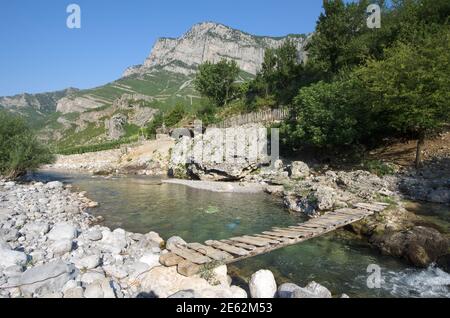 Kleine Holzbrücke auf einem Nebenfluss des Flusses CEMI in der Gemeinde Kelmend, Albanien Stockfoto