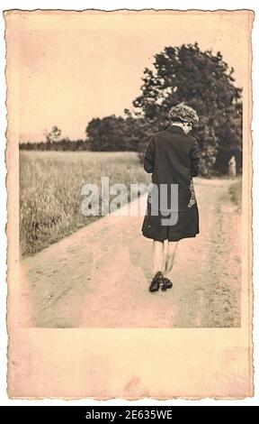 DEUTSCHLAND - UM 1960s: Retro-Foto zeigt, wie Frau spazieren geht. Schwarzweiß-Fotografie aus den goldenen Sechzigern. 1960s Stockfoto