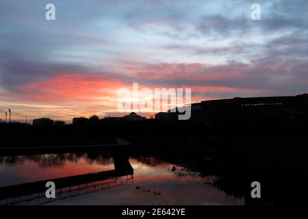 Blick in der Morgendämmerung über die Teiche und Schilfbeete im öffentlichen Park Las Llamas von Atlantic Sardinero Santander Cantabria Spanien spiegelte den orangefarbenen Himmel wider Stockfoto