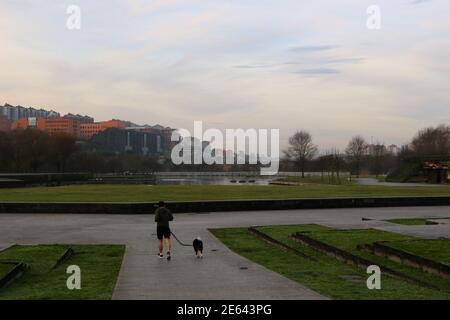 Mann läuft mit seinem Hund an der Leine am frühen Morgen im Atlantic Park Santander Cantabria Spanien Stockfoto