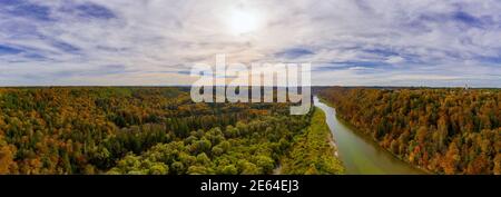 Herbstpanorama Luftaufnahme über die Isar in südbayern, eingerahmt von herrlich bunten Bäumen an einem schönen Abend, die Sonne scheint. Stockfoto