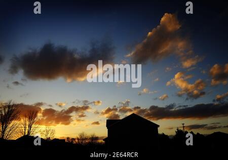 Ein Haus, das gegen den Abendhimmel silhouettiert. Stockfoto