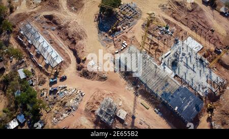 Luftaufnahme das Projekt baut ein großes Gebäude. Gelbe Baukran und Arbeiter arbeiten, Drohne Fotos Stockfoto