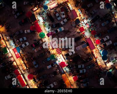 Luftaufnahme auf dem Nachtmarkt. Es gibt viele Menschen, Autos und Geschäfte. Stockfoto