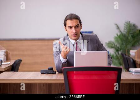 Junge Geschäftsmann Mitarbeiter in Mobbing-Konzept am Arbeitsplatz Stockfoto