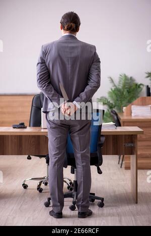 Junge Geschäftsmann Mitarbeiter in Mobbing-Konzept am Arbeitsplatz Stockfoto