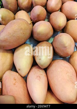 Frische hellrote Mangos auf dem Stand zum Verkauf in Der Markt Stockfoto