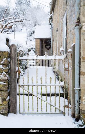 Cotswold Steinhaus Tor in Swinbrook im Schnee. Swinbrook, Cotswolds, Oxfordshire, England Stockfoto