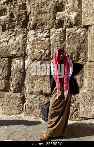 Damaskus, Syrien 03-27-2010: Ein syrischer Araber mittleren Alters mit Schnurrbart steht vor einem historischen Gebäude. Er trägt keffiyeh, agal, jubba Stockfoto