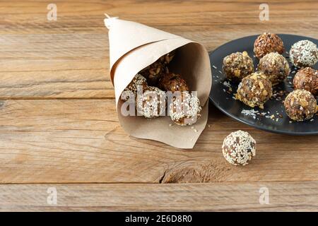 Energiebisse mit Nüssen, Samen, Trockenfrüchten und Honig - vegane oder vegetarische rohe Bio-Snack-Müslibisse auf Holzhintergrund. Stockfoto