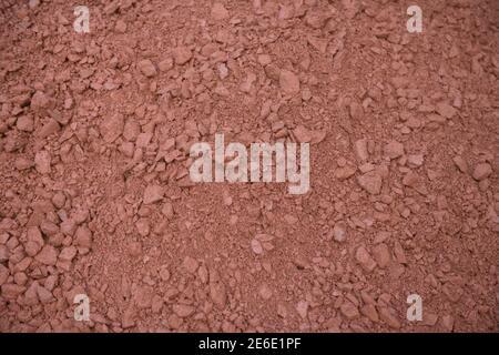 Hintergrund oder Textur von Red Stone Scalpings auf dem Drive of a Country Cottage Garden in Rural Devon, England, UK Stockfoto