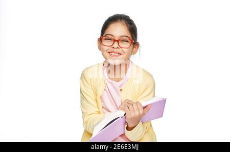 Schönes multiethnisches Mädchen mit Brillen hält Buch in den Händen und lacht und schaut auf die Kamera Stockfoto