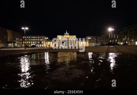 Berlin, Deutschland. Januar 2021. Das Brandenburger Tor spiegelt sich leicht in einem Eisschild wider. Quelle: Paul Zinken/dpa-Zentralbild/dpa/Alamy Live News Stockfoto