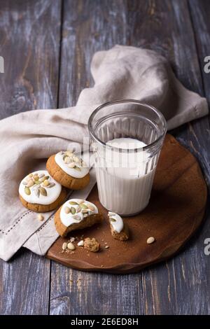 Weihnachts-Lebkuchen mit Nüssen und Samen mit Milch auf einem Holztisch. Köstliche hausgemachte Leckerbissen für Kinder und Weihnachtsmann Stockfoto