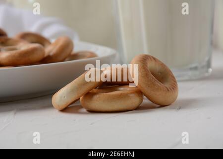 Runde Bagels mit Milch auf weißem Hintergrund Stockfoto