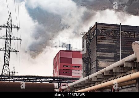 Eine Fabrik, Stromleitungen, Rauchrohre. Luftverschmutzung. Stockfoto