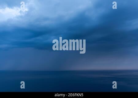 Sturmwolken über dem Meer sind schwarz und blau. Ein Hurrikan kommt, ein Regenguss. Natürlicher finsterer Hintergrund. Sturmwarnung. Wetterkatastrophen. Das se Stockfoto