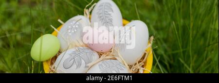 osterfeiertagskonzept. Osterdekor mit hell bemalten Eiern im Gras. Web-Banner. Vorlage für Design.Ostern Komposition mit bunten Eiern in Stockfoto