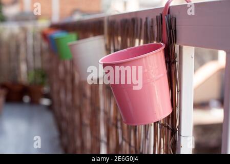 Reihe von farbigen Blumentöpfen hängen auf dem Geländer von Eine Terrasse Stockfoto