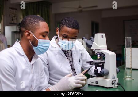 Junge schwarze Wissenschaftler führen einige Experimente im Labor durch Stockfoto