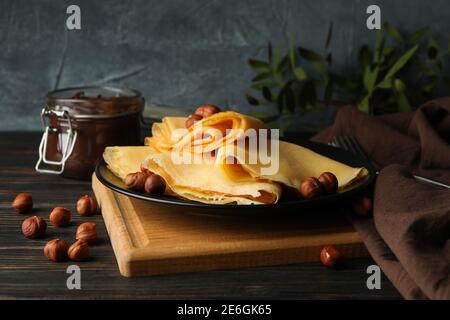 Konzept von leckeren Frühstück mit Crepes mit Nüssen und Schokolade Kleben Sie auf Holztisch Stockfoto