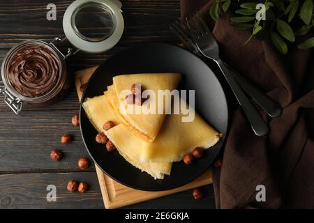 Konzept des Frühstücks mit Crepes mit Schokoladenpaste und Nüssen Auf Holztisch Stockfoto