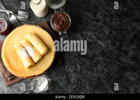 Konzept des Frühstücks mit Crepes mit Schokoladenpaste auf schwarz Rauchtisch Stockfoto