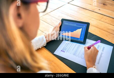 Geschäftsfrau analysiert Marktentwicklung mit Tablet Stockfoto