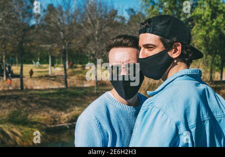 Nahaufnahme Porträt von jung Gay Paar tragen schwarz schützend Gesichtsmaske und Sonnenbrille Stockfoto