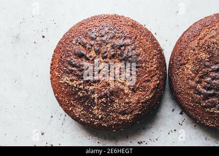 Zwei braune Zucker Zimt Kuchen auf einem Kühlgestell über einem Naturstein Hintergrund. Stockfoto