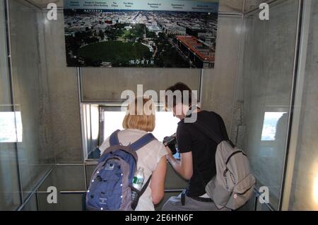 Auf dem George Washington Monument sehen Touristen aus dem Fenster einen Rucksack, Kamera, Filmposter, Kunstwerke, Kunsthochhaus Stockfoto