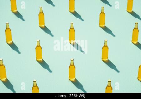 Mehrere Bierflaschen mit langen Schatten auf hellblauem Hintergrund. Mockups von vollen Glasflaschen ohne Etikett. Retro Getränkeflasche Konzept. Stockfoto