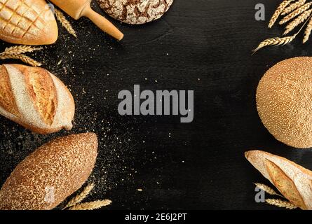 Verschiedene Brotsorten auf schwarzem Hintergrund. Draufsicht. Stockfoto