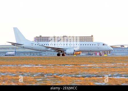Das Flugzeug beschleunigt entlang der Landebahn vor dem Hintergrund Eines Teminals Stockfoto