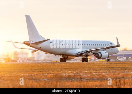 Das Flugzeug beschleunigt vor dem Hintergrund entlang der Landebahn Des Abendhimmels Stockfoto