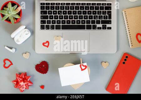 Geschenkverpackung Valentinstag Geschenke in der Nähe von modernen Gadgets auf grauen Tisch Draufsicht. Valentinstag-Konzept Stockfoto