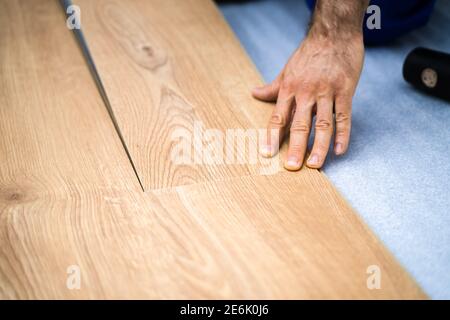 Holzboden Renoviert. Bauarbeiter, Der Neue Laminat-Installation Macht Stockfoto